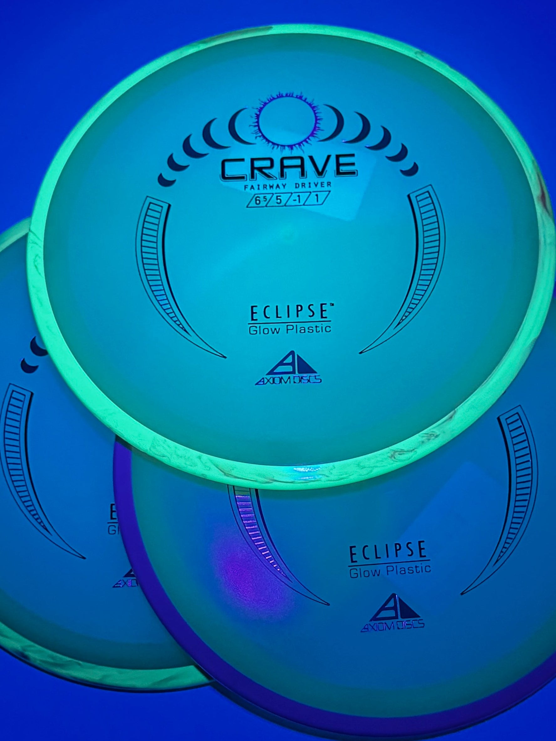Three glowing discs on a blue surface under ultraviolet light